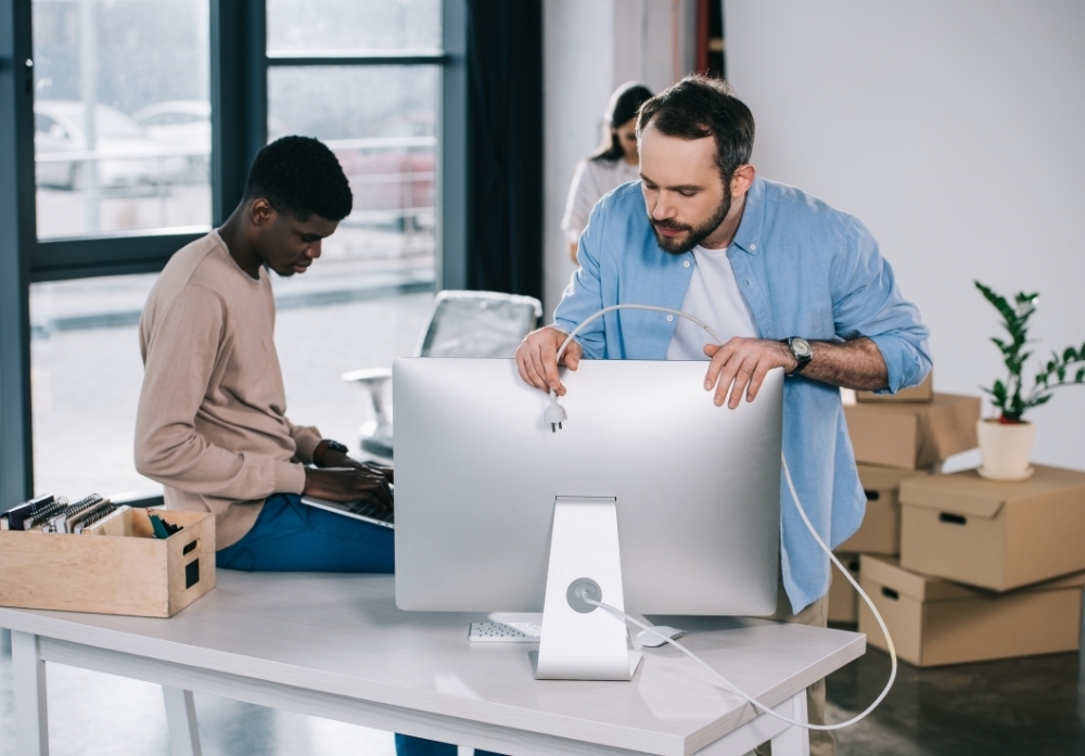 a professional man holding a monitor in the office