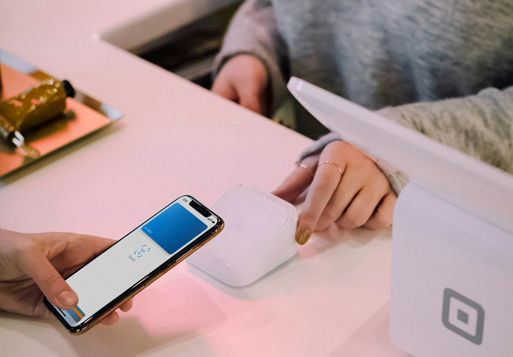 someone using a phone to pay in the cashier of a store