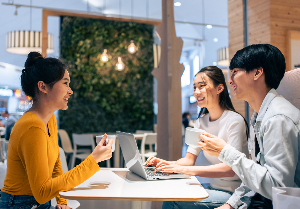 friends talking and using a laptop in a restaurant