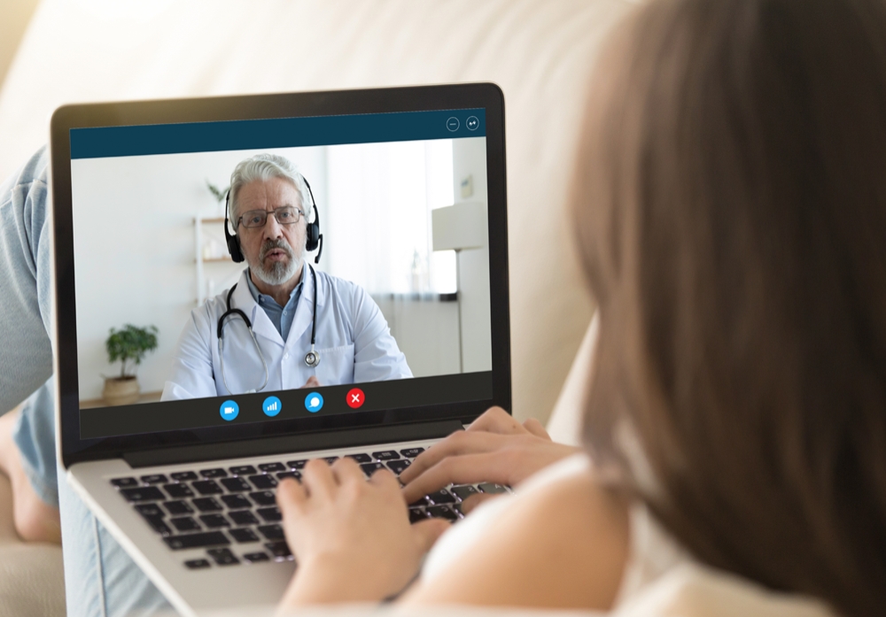 Patient Engaged in Virtual Consultation on Laptop