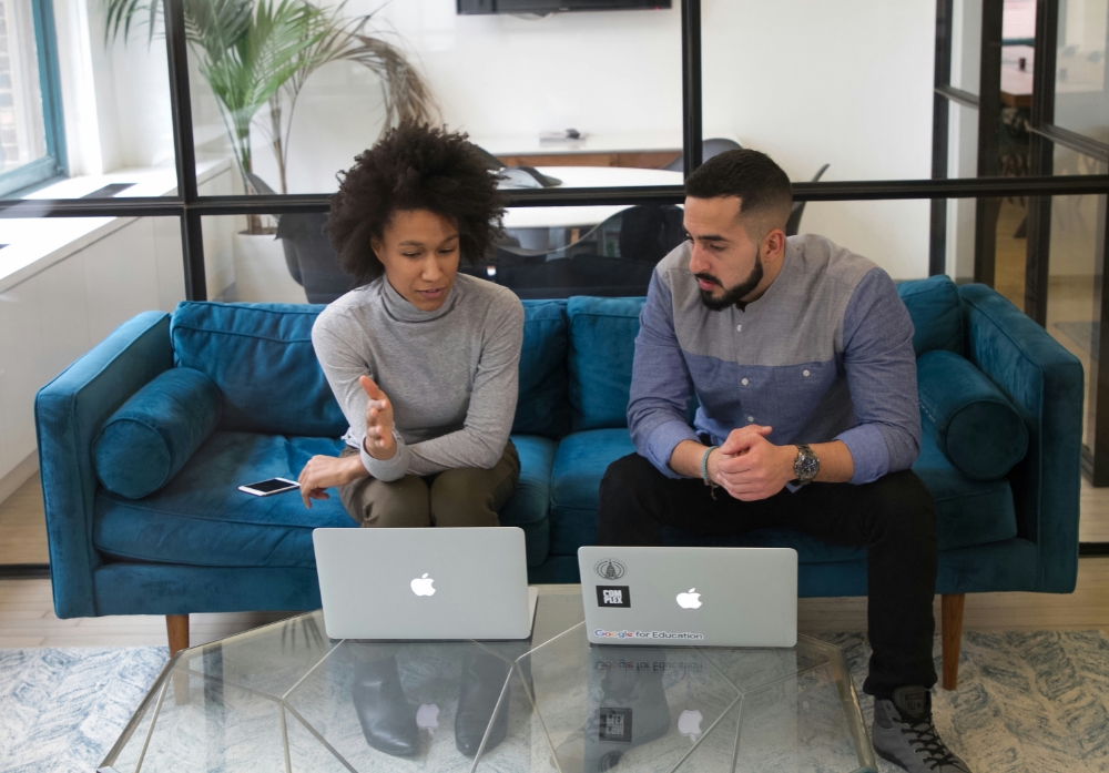 employees talking over MacBook<br />
