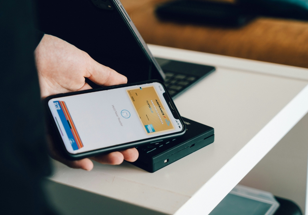 Up close shot of hand holding an iPhone using tap pay